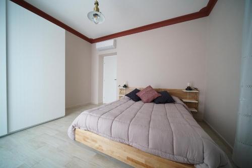 ein Schlafzimmer mit einem Bett mit einem Kopfteil aus Holz in der Unterkunft CASA VACANZE DA DANIELE in Marta