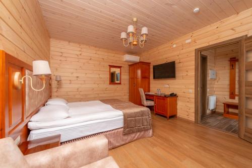 a bedroom with a bed and a desk in a room at Brech Resort&Spa in Gurinovka Staraya