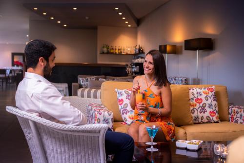 a man and a woman sitting on a couch at Enotel Sunset Bay in Ponta do Sol