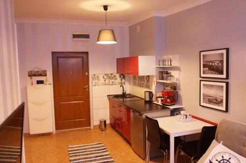 a small kitchen with a counter and a table at Morski Apartament in Ustka