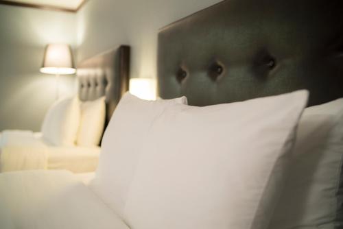 a close up of a bed with a white pillow at Hôtel Le Rivage in Rosemère