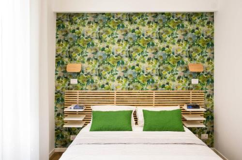 a bedroom with a large bed with green pillows at Four Elements in Rome