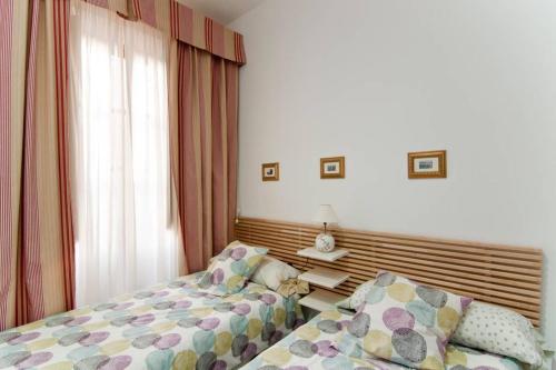 - une chambre avec deux lits à côté d'une fenêtre dans l'établissement Apartamento Centro Historico, à Malaga