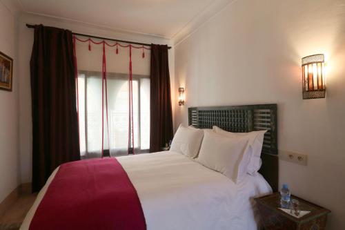 a bedroom with a large bed and a window at Riad Celia in Marrakech