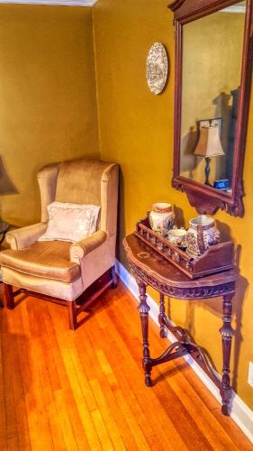 a room with a chair and a table with a mirror at Lilac Inn in Brandon