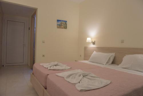 
A bed or beds in a room at Alkyon Beach Hotel
