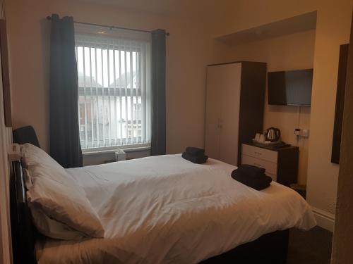 a bedroom with a white bed and a window at Langroyd Hotel in Blackpool