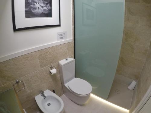 a bathroom with a toilet and a sink at La Residenza del Reginale in Siracusa