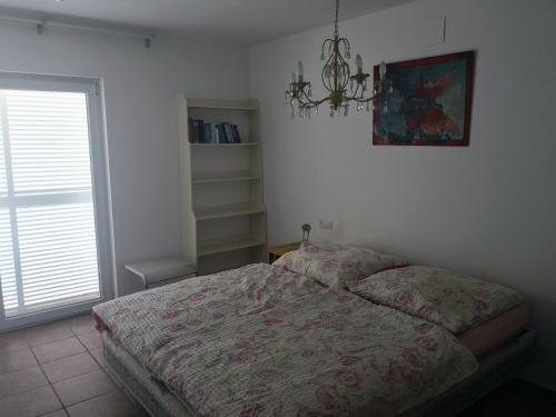 德拉塞爾瓦港的住宿－La Vista，一间卧室设有一张床、一个窗户和一个吊灯。