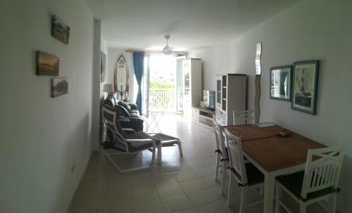 uma cozinha e sala de estar com mesa e cadeiras em Large beachfront apartment Medano em El Médano