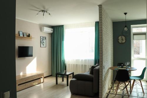 a living room with a couch and a table at Blue apartments on Kotsyubinsky Avenue in Vinnytsya