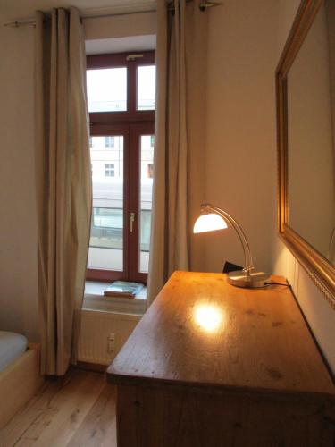 a lamp on a wooden table in front of a window at Kleine Altstadt-Wohnung mit Terrasse in Wismar
