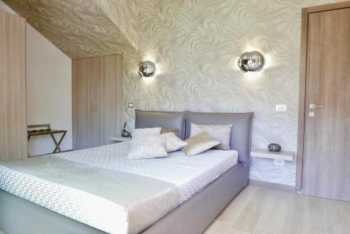 1 dormitorio con cama y pared con estampados en Phoenix Garda Hills, en Sirmione