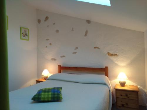 a bedroom with a bed and two lamps on tables at Logis de Flamenac in Pranzac