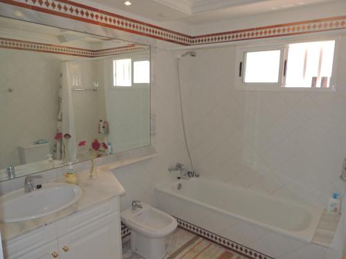 a bathroom with a sink and a tub and a toilet at Romantic Retreat with Marine View in Acantilado de los Gigantes