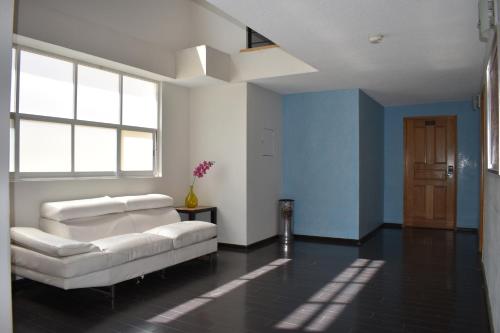 sala de estar con sofá blanco y paredes azules en Centro 19 Hotel, en Querétaro