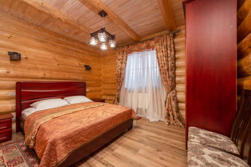 a bedroom with a bed in a log cabin at Brech Resort&Spa in Gurinovka Staraya