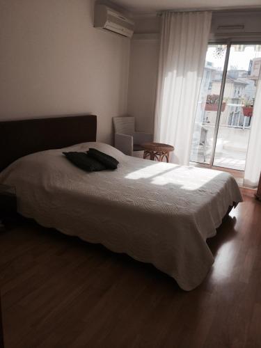 une chambre avec un grand lit blanc et une fenêtre dans l'établissement Appartamento Sole, à Nice