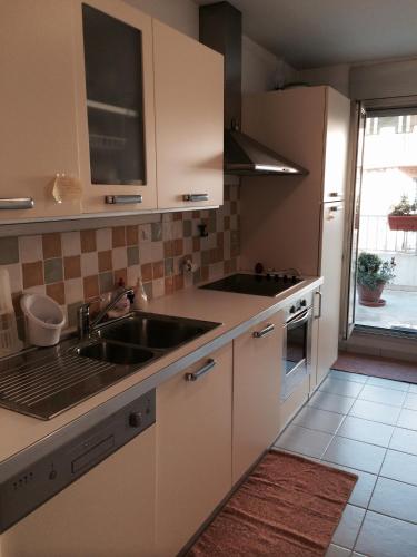 une cuisine avec des armoires blanches et un évier dans l'établissement Appartamento Sole, à Nice