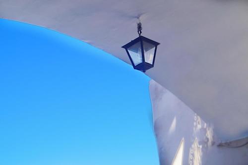 a street light in the snow with a blue light at Tataki Hotel in Fira
