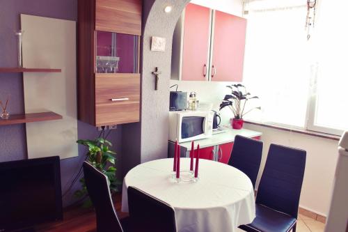 Elle comprend une petite cuisine avec une table et des bougies rouges. dans l'établissement Apartment Živković, à Crikvenica