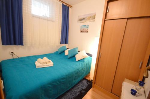 a bedroom with a blue bed with towels on it at Apartment Živković in Crikvenica