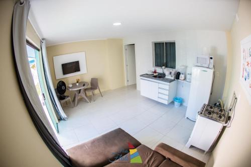 eine Küche mit einem Kühlschrank und einem Tisch in der Unterkunft Porto Flats in Porto De Galinhas
