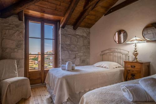 a bedroom with two beds and a window at Artemis Stone Villa in Vasilikos