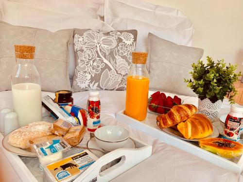 a breakfast tray with bread and orange juice and milk at Apartments Alfacinha Ajuda in Lisbon