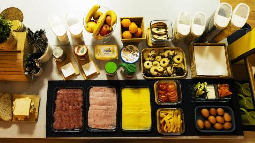 a table topped with trays of food and other foods at Nitra Glycerin Hostel in Nitra