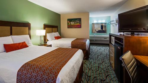 Habitación de hotel con 2 camas y TV de pantalla plana. en Key West Inn - Fairhope, en Fairhope