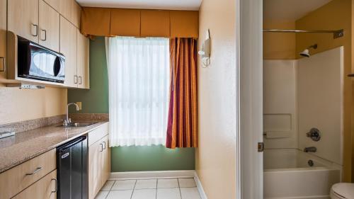 a small kitchen with a sink and a shower at Key West Inn - Fairhope in Fairhope