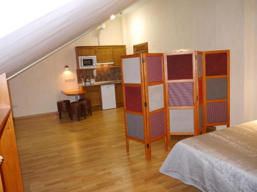 a room with a bed and a kitchen with a staircase at Villa Russell Hotel&Apartments in Torla