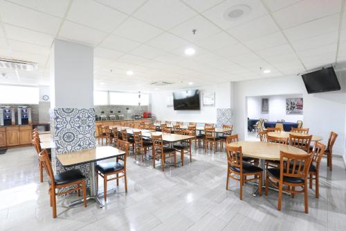 a dining room filled with tables and chairs at San Juan Airport Hotel in San Juan