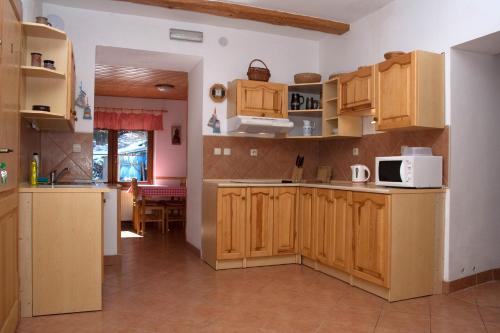 a large kitchen with wooden cabinets and a table at Penzion u Vodopádu in Karlova Studánka