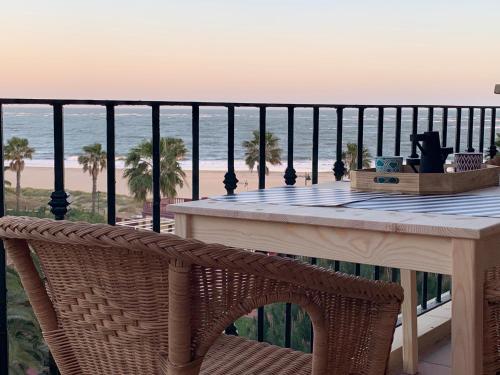 - une table sur un balcon avec vue sur l'océan dans l'établissement Mirando al mar. Primera linea de playa, à Isla Canela