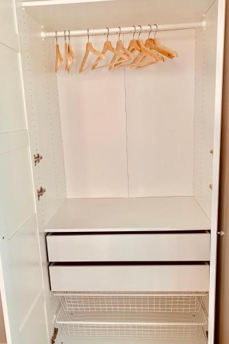 a white closet with white shelves and shoes at Apartments Alfacinha Ajuda in Lisbon