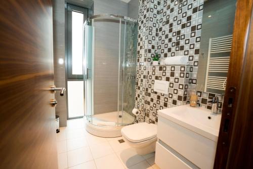 a bathroom with a shower and a toilet and a sink at Hotel Royal Gold City - Hotel Ruža in Sarajevo