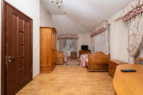a bedroom with a bed and a desk and a door at Brech Resort&Spa in Gurinovka Staraya
