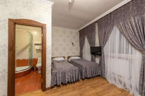 a bedroom with a bed and a bathroom with a mirror at Brech Resort&Spa in Gurinovka Staraya