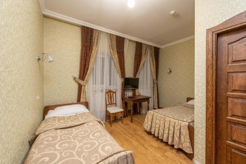 a bedroom with two beds and a desk and a window at Brech Resort&Spa in Gurinovka Staraya