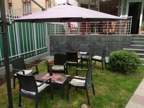 a group of tables and chairs under an umbrella at Hotel Royal Gold City - Hotel Ruža in Sarajevo