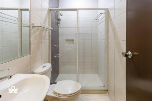 uma casa de banho com um chuveiro, um WC e um lavatório. em Lorenzzo Suites Makati em Manilla