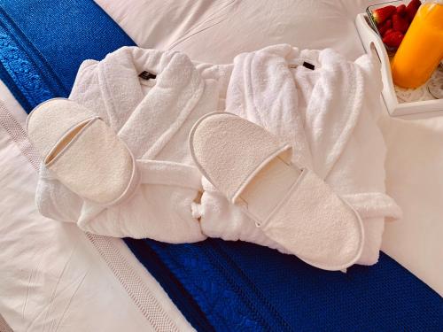 a white towel on a bed with a box of fruit at Apartments Alfacinha Ajuda in Lisbon