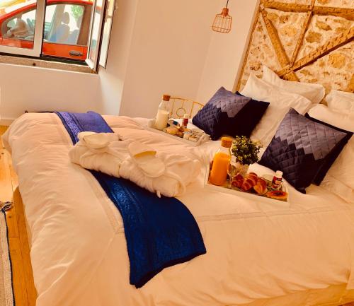 a large white bed with some food on it at Apartments Alfacinha Ajuda in Lisbon