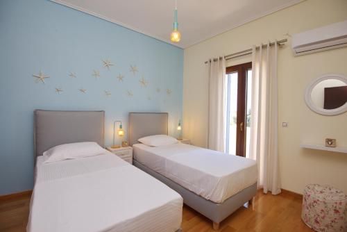1 dormitorio con 2 camas y ventana en Lidromi Home (Blue), en Centro histórico de Alónnisos