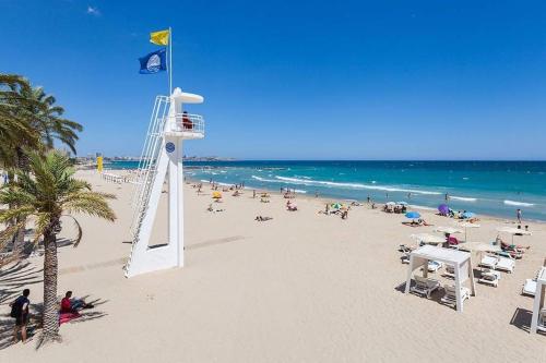 a beach with a life guard tower and a crowd of people at Jonás 1 in Alicante