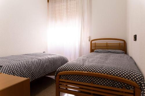 two twin beds in a room with a window at Jonás 1 in Alicante