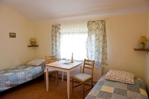 a room with two beds and a table and a window at Kietlice nad Mamrami in Węgorzewo