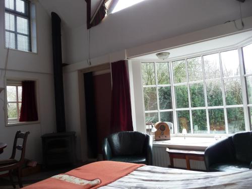 a bedroom with a bed and a large window at Selatuinen in Appelscha